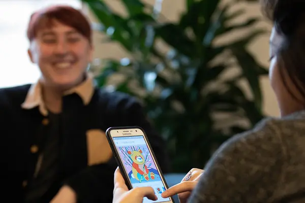 student looking at phone and chatting with another student